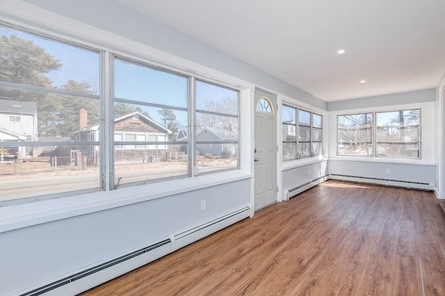 unfurnished sunroom featuring a baseboard heating unit