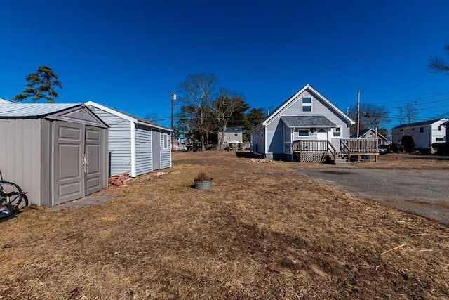 view of yard with a shed, a deck, and an outbuilding