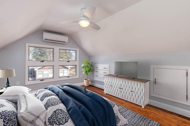 bedroom featuring vaulted ceiling, ceiling fan, a wall mounted air conditioner, and wood finished floors