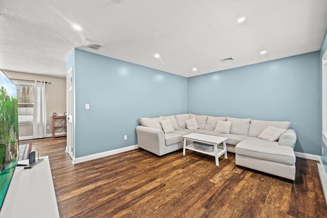 living room with dark hardwood / wood-style floors and a textured ceiling