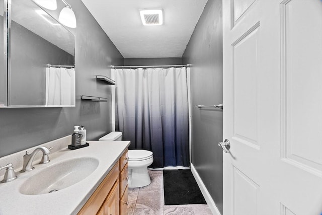 bathroom featuring vanity, curtained shower, and toilet