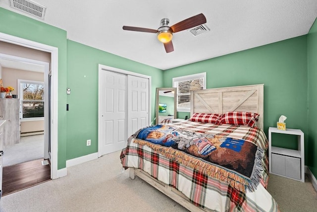 bedroom featuring ceiling fan, carpet floors, baseboard heating, and a closet