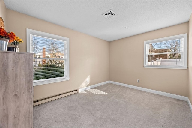 carpeted spare room featuring a baseboard radiator and a textured ceiling