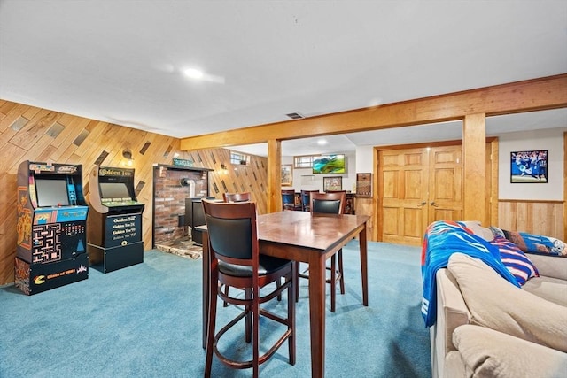 carpeted dining area with wood walls