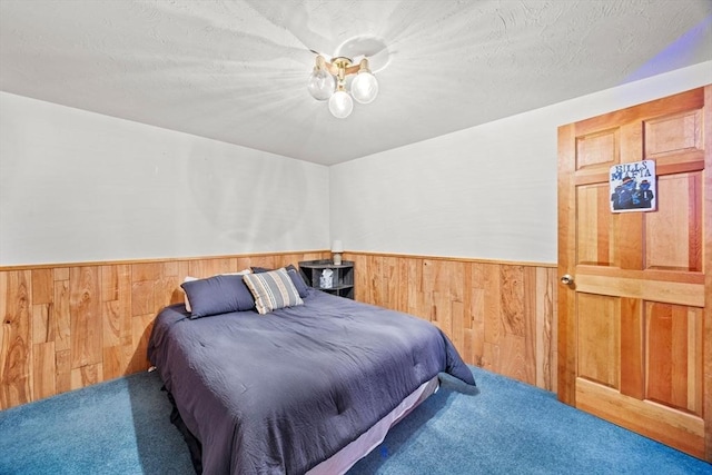 carpeted bedroom featuring wood walls