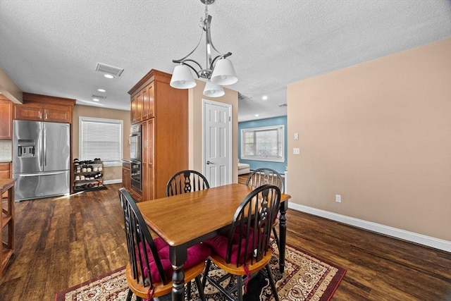 dining room featuring dark hardwood / wood-style flooring and a textured ceiling