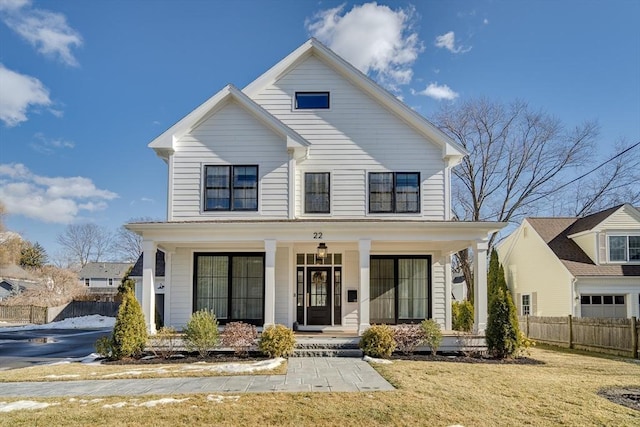 view of front of home featuring covered porch, a front yard, and fence