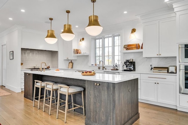 kitchen featuring a kitchen island with sink, ornamental molding, white cabinets, and open shelves