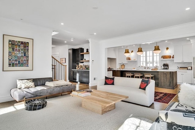 living room with stairway, recessed lighting, wood finished floors, and ornamental molding