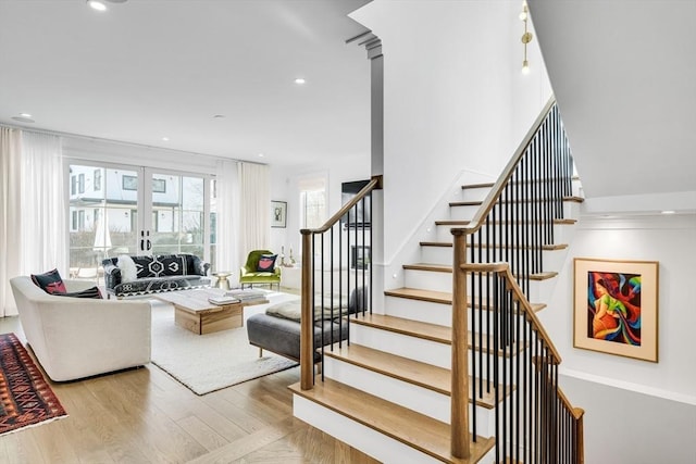 stairs featuring wood finished floors, recessed lighting, and french doors