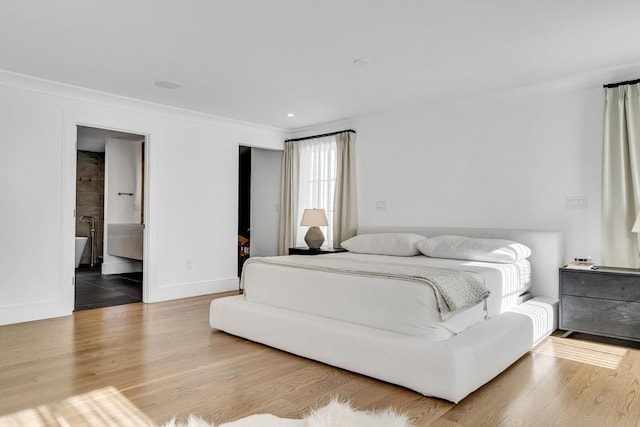 bedroom featuring wood finished floors, baseboards, and ornamental molding