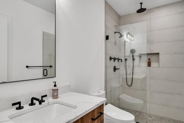 full bathroom featuring vanity, toilet, and a tile shower