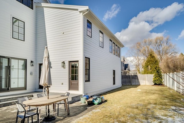 back of property with a fenced backyard, a yard, and a patio