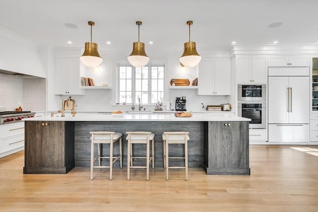 kitchen with a spacious island, open shelves, white cabinets, stainless steel appliances, and a sink