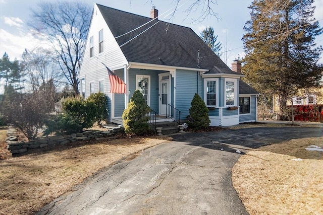 view of front of home featuring a chimney and a shingled roof