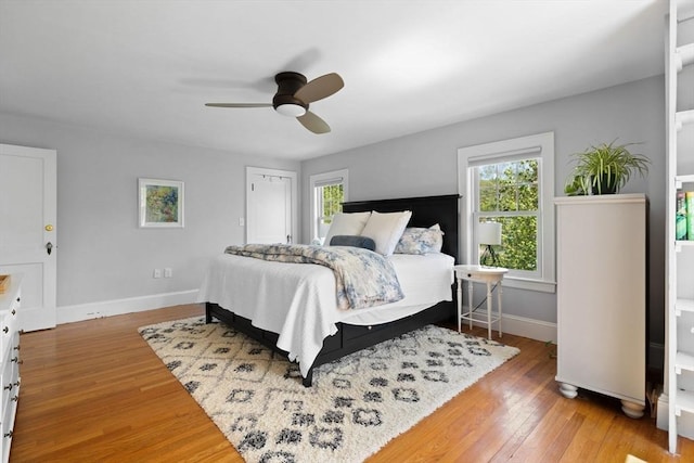 bedroom with wood finished floors, baseboards, and ceiling fan