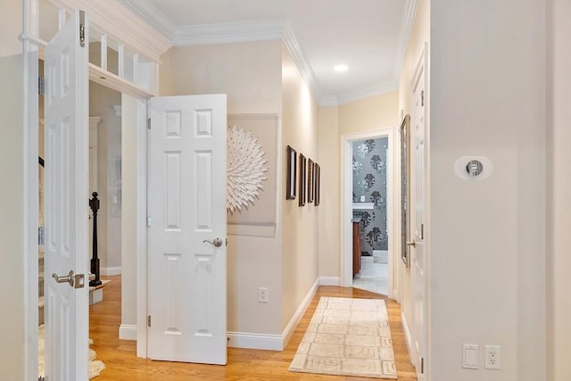 corridor featuring light wood-style floors, crown molding, baseboards, and recessed lighting