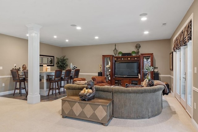 carpeted living area with decorative columns, recessed lighting, and baseboards