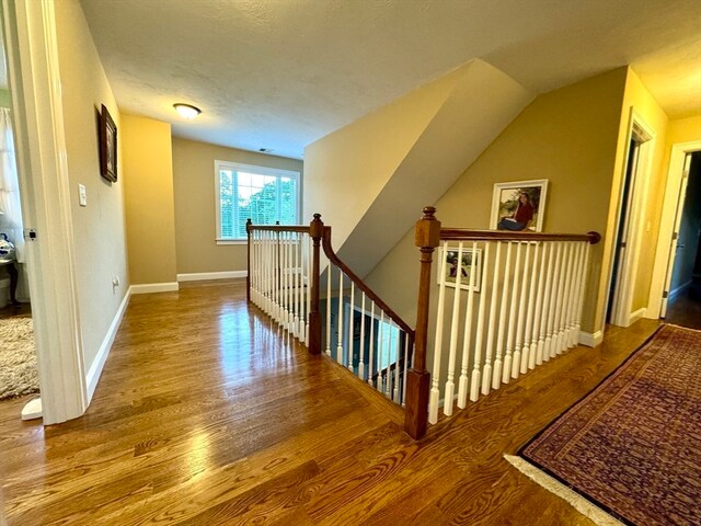 interior space with hardwood / wood-style flooring, a textured ceiling, and lofted ceiling