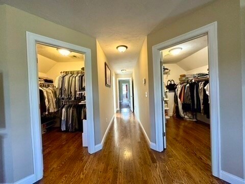 hall with lofted ceiling and dark hardwood / wood-style floors