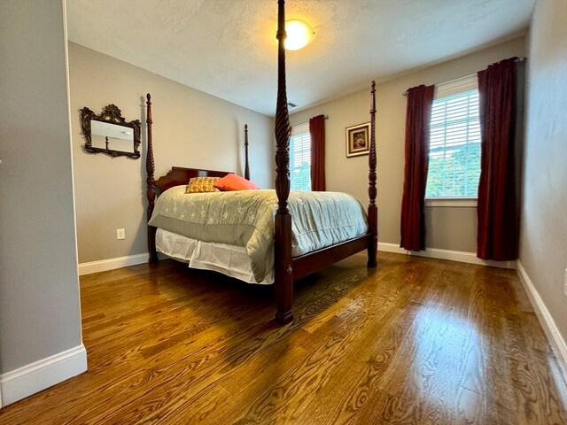 bedroom featuring dark hardwood / wood-style floors and a textured ceiling