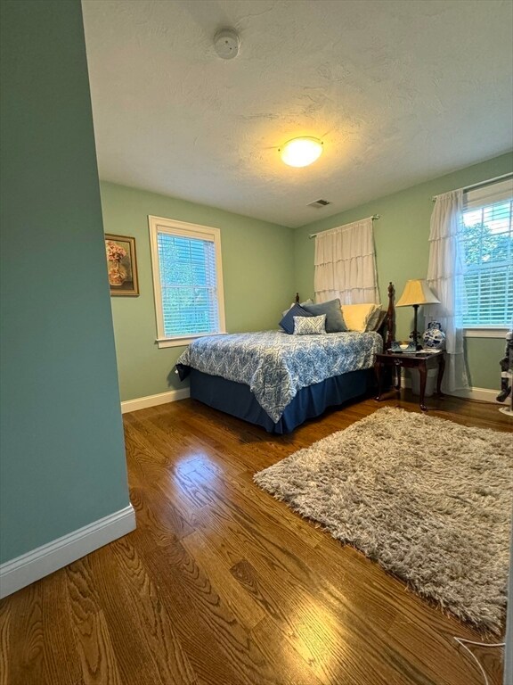 bedroom with a textured ceiling and hardwood / wood-style flooring