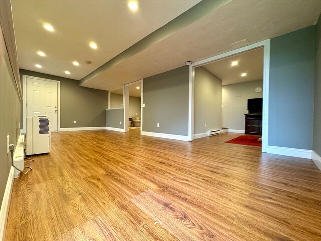 unfurnished living room with light hardwood / wood-style floors and baseboard heating