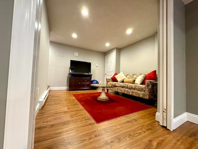 living room featuring baseboard heating and light wood-type flooring