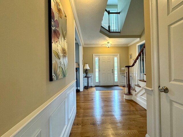 entrance foyer with crown molding and hardwood / wood-style flooring