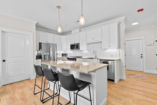 57 Long Point Rd Unit 110, Lakeville, MA 02347 - kitchen featuring appliances with stainless steel finishes, ornamental molding, a kitchen breakfast bar, a center island, and white cabinetry