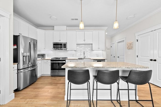 57 Long Point Rd Unit 110, Lakeville, MA 02347 - kitchen featuring appliances with stainless steel finishes, ornamental molding, a sink, a kitchen island, and a breakfast bar