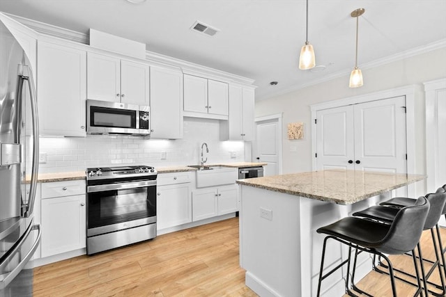 57 Long Point Rd Unit 110, Lakeville, MA 02347 - kitchen with appliances with stainless steel finishes, a center island, decorative backsplash, a breakfast bar, and white cabinets