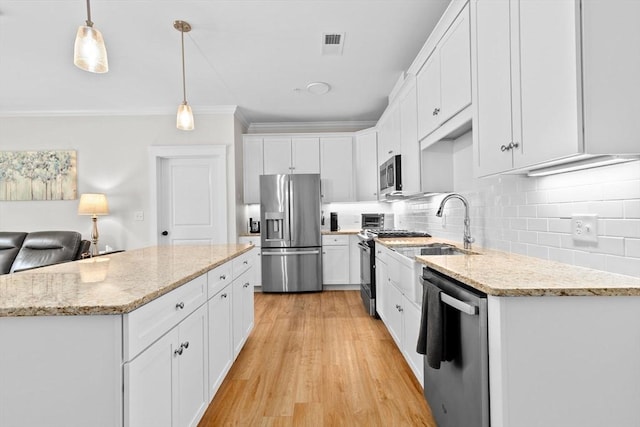 57 Long Point Rd Unit 110, Lakeville, MA 02347 - kitchen featuring stainless steel appliances, ornamental molding, white cabinets, backsplash, and a kitchen island