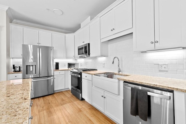 57 Long Point Rd Unit 110, Lakeville, MA 02347 - kitchen featuring appliances with stainless steel finishes, backsplash, white cabinetry, and a sink