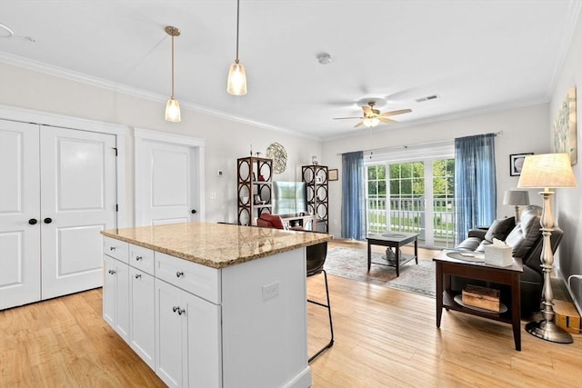 57 Long Point Rd Unit 110, Lakeville, MA 02347 - kitchen featuring light wood finished floors, crown molding, ceiling fan, white cabinetry, and a center island
