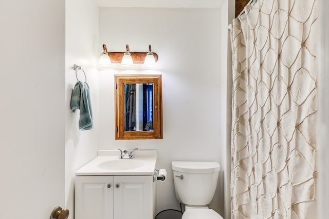 bathroom featuring vanity, toilet, and walk in shower