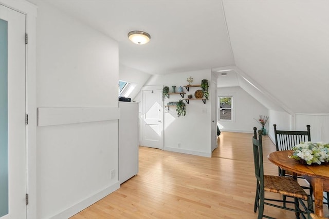 additional living space featuring healthy amount of natural light, light wood-style flooring, lofted ceiling, and baseboards