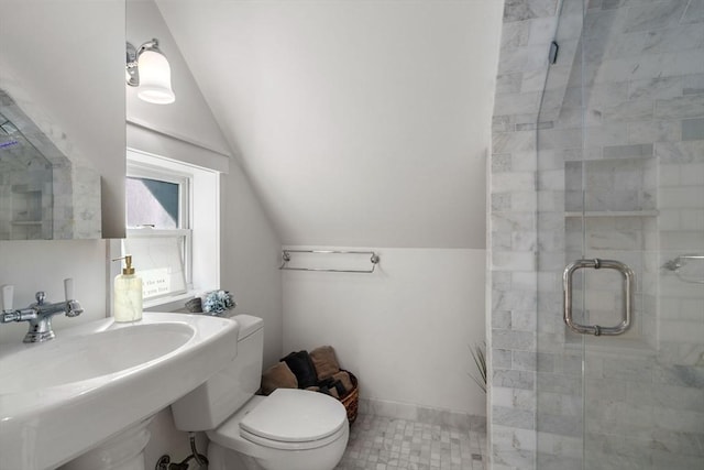 full bathroom featuring a shower stall, lofted ceiling, a sink, toilet, and tile patterned flooring