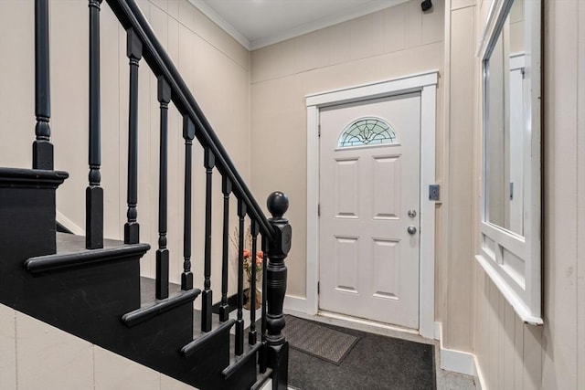 foyer with ornamental molding and stairway