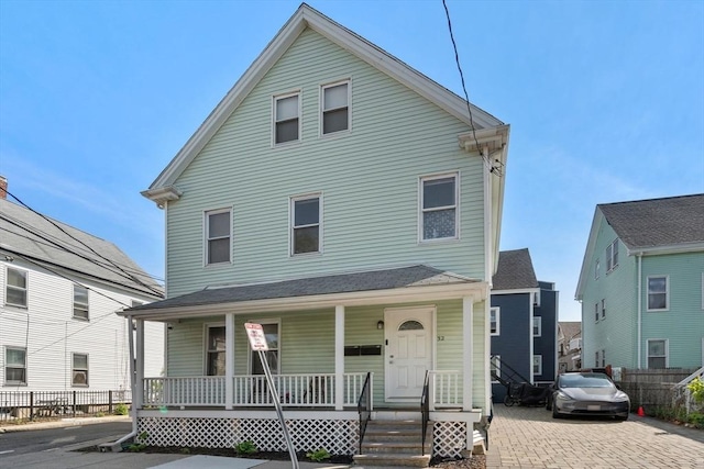 view of front of home with covered porch and fence