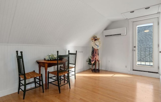 additional living space featuring wood finished floors, vaulted ceiling, and an AC wall unit