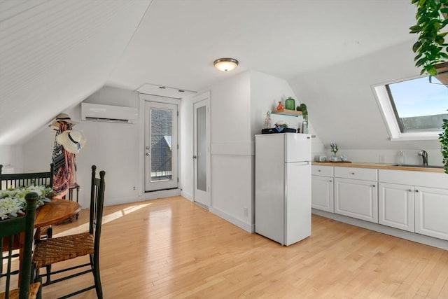 bonus room with a wall mounted AC, a sink, light wood finished floors, lofted ceiling, and a skylight