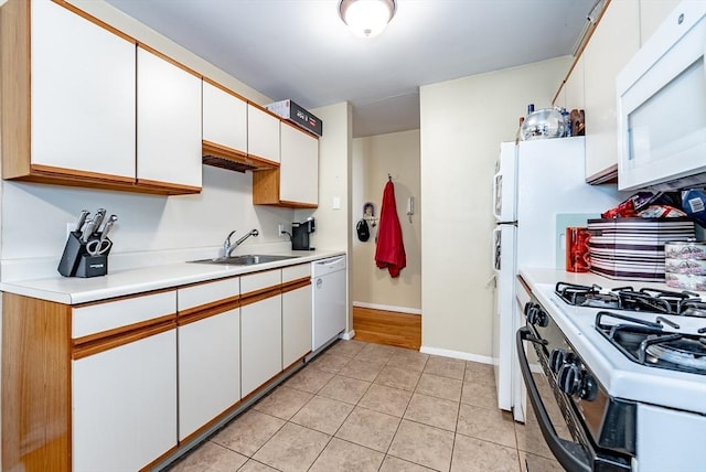 kitchen featuring white appliances, light tile patterned floors, a sink, light countertops, and white cabinetry