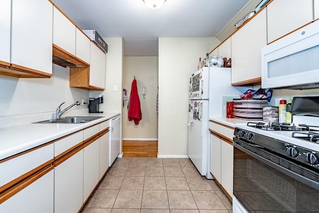 kitchen with light countertops, light tile patterned floors, white appliances, white cabinetry, and a sink