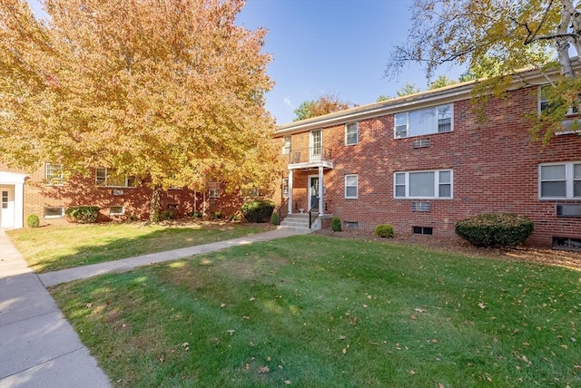 view of front of property with brick siding and a front lawn