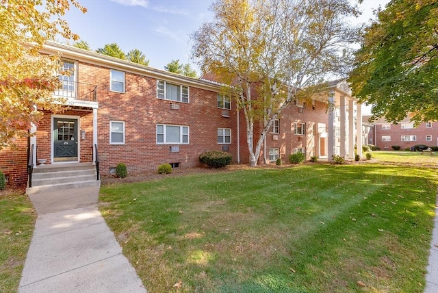 view of front of home with brick siding and a front lawn