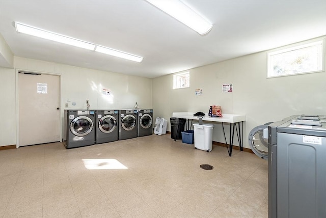 community laundry room with tile patterned floors, independent washer and dryer, and baseboards