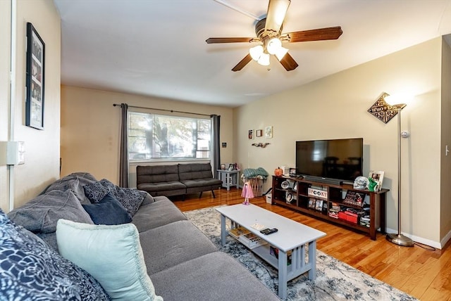 living area featuring baseboards, ceiling fan, and wood finished floors