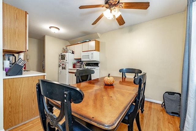 dining area featuring a ceiling fan, light wood-type flooring, and baseboards