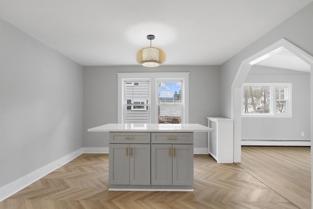 kitchen featuring hanging light fixtures, gray cabinets, light parquet floors, and a kitchen island